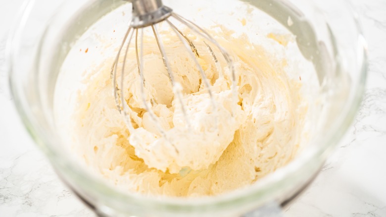 Making frosting with whisk in bowl