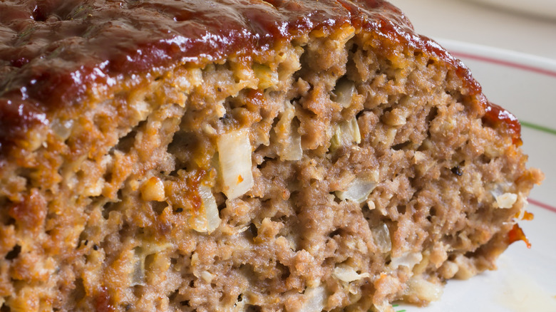 Plate of meatloaf with a slice cut out of it