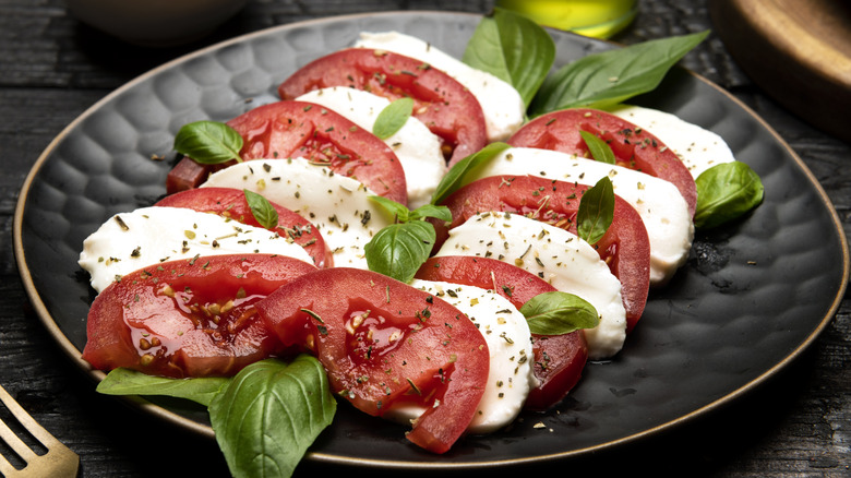 caprese salad on a black plate