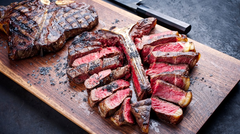 Sliced steak on wooden board