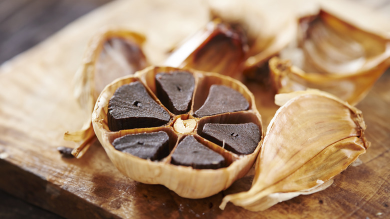 A head of black garlic sliced open in half.