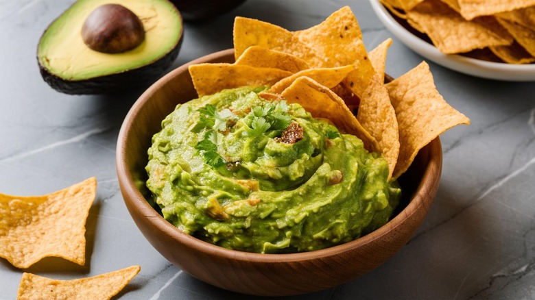 Bowl of guacamole with chips in it