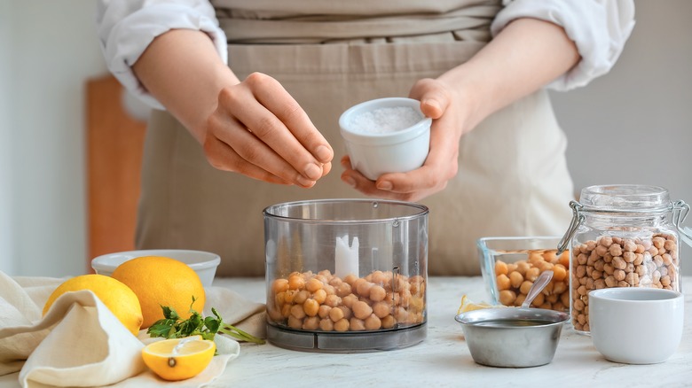 Cook making hummus with food processor