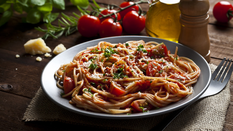 Pasta with tomato sauce in a bowl with ingredients