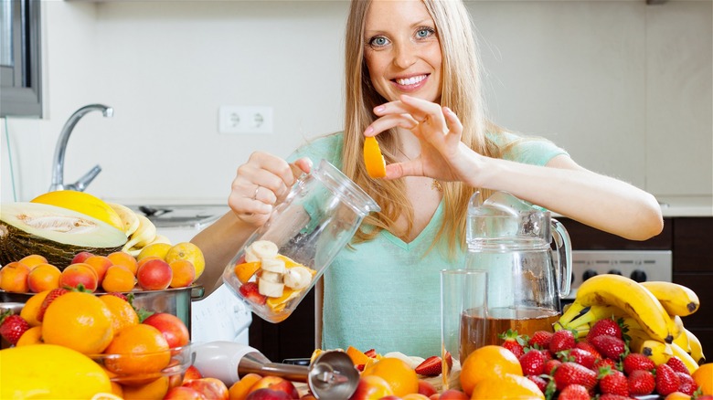 woman adding fruit to pitcher