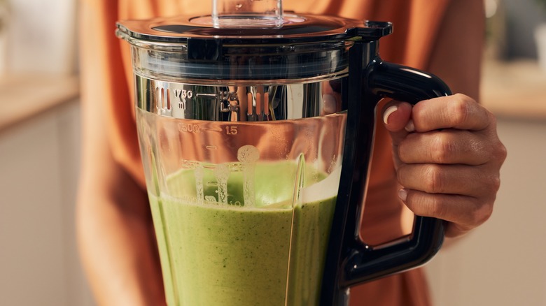 Green smoothie in a plastic jar blender