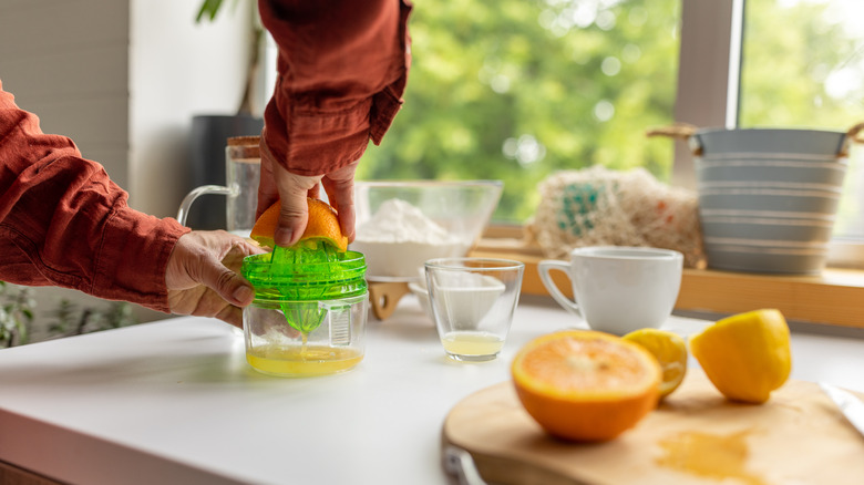 Person juicing oranges by hand