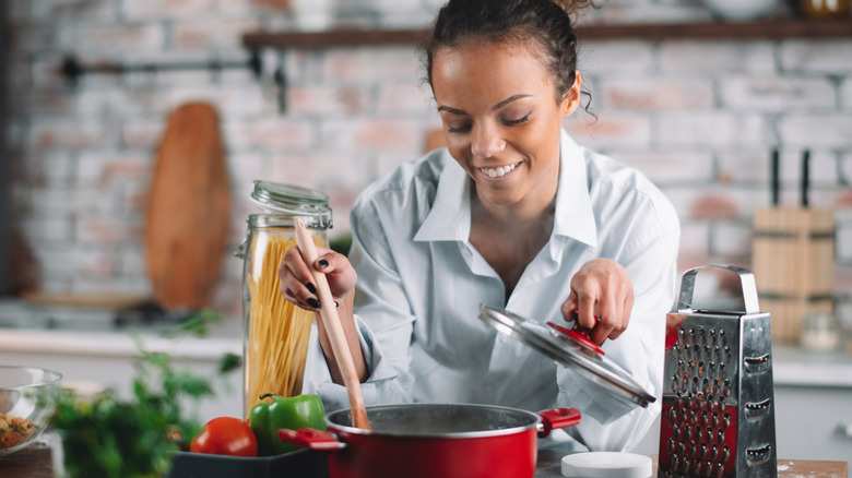 woman stirring pot on stove