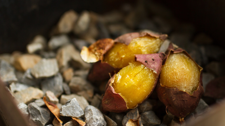 sweet potatoes roasting on hot stones