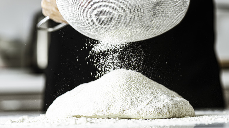 adding flour to dough