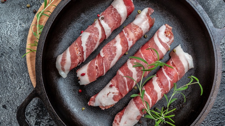 Meat wrapped in bacon in pan