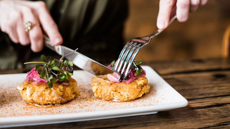 Person cutting into crab cake