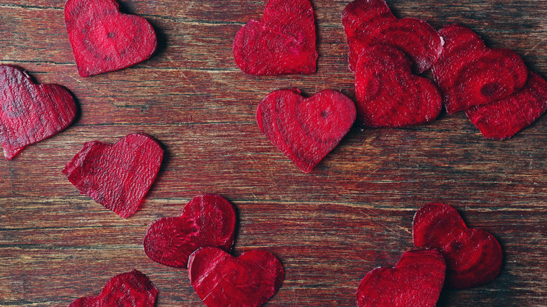 Heart shaped raw beet slices on a cutting board