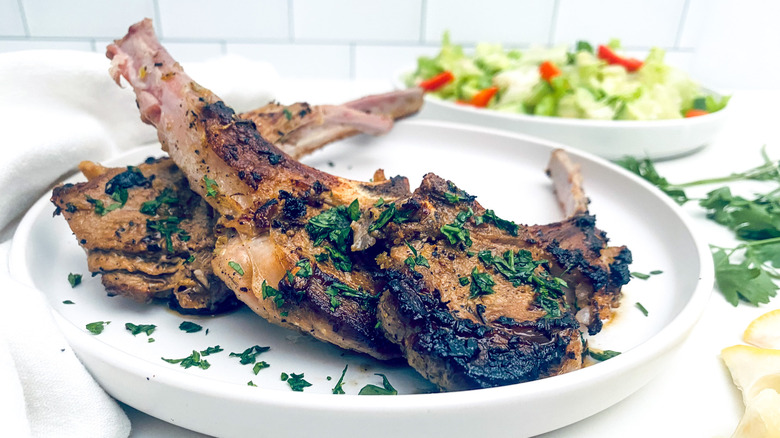 lamb chops with herbs on white plate