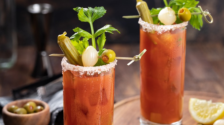 Two Bloody Mary cocktails with vegetable garnishes