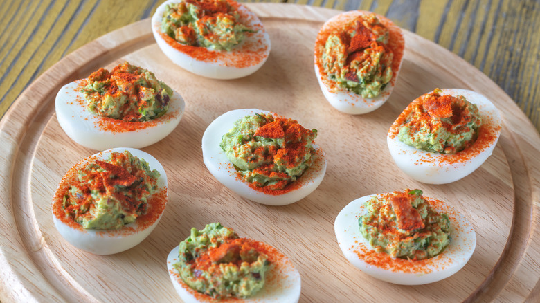 deviled eggs with guacamole and paprika