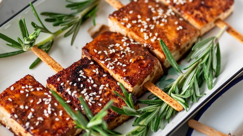 Grilled tofu with wood skewers on a serving platter