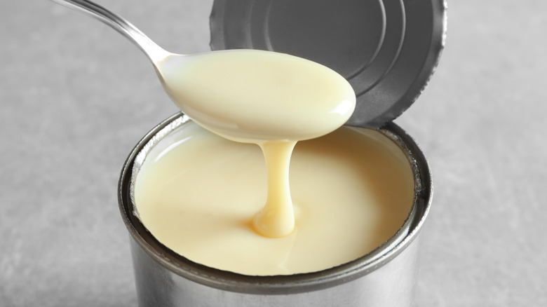 opened can of condensed milk with spoon