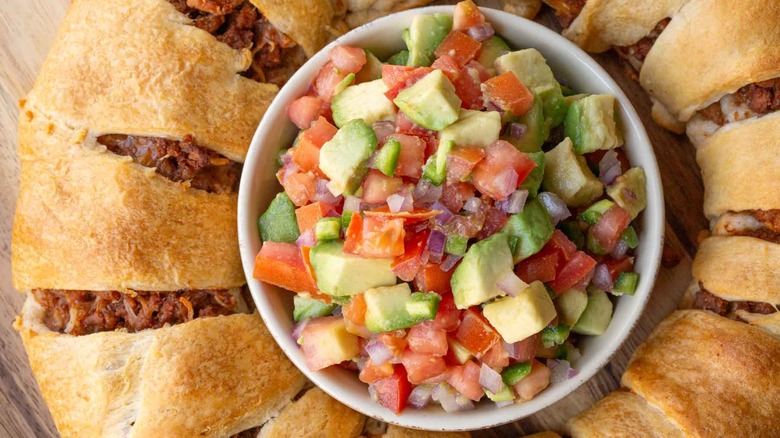 meat-filled bread ring surrounding a bowl of salsa