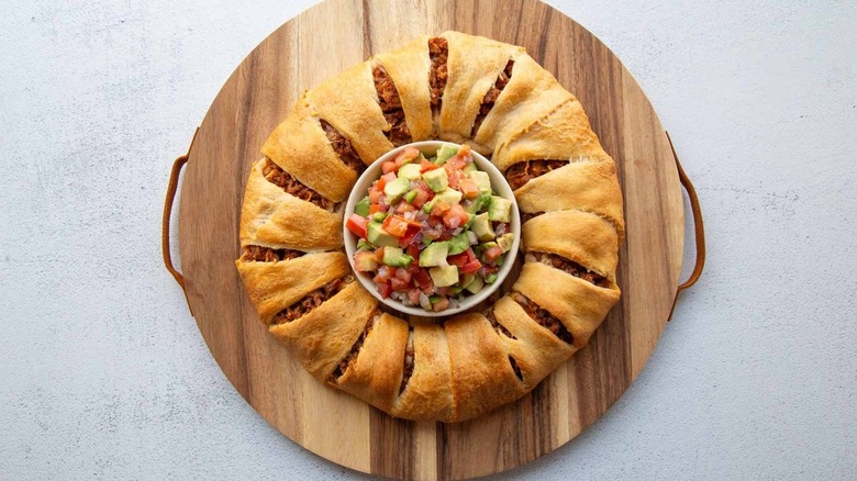 meat-filled bread ring surrounding a bowl of salsa