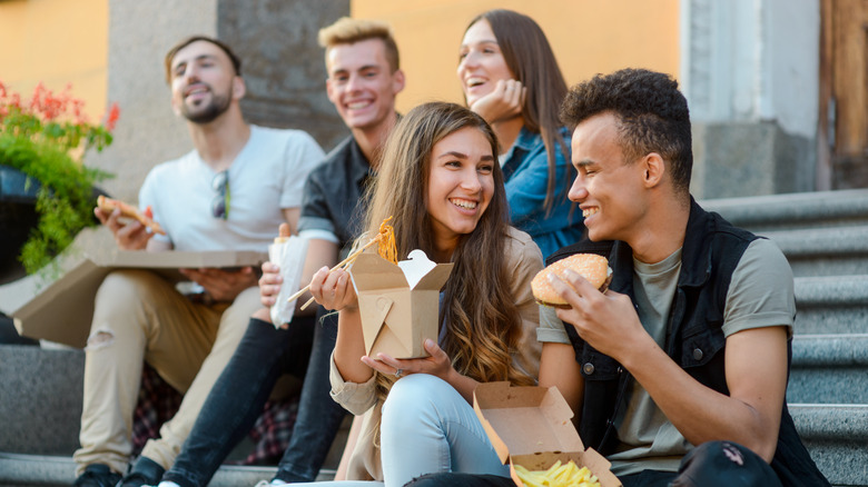 Young people enjoy food on steps