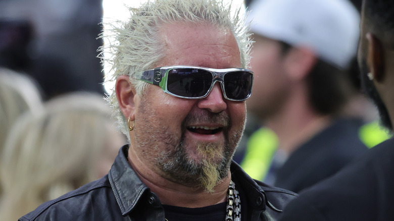 Guy Fieri smiling in sunglasses