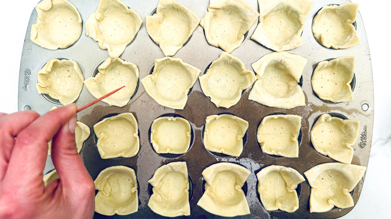 pricking pastry in muffin tin