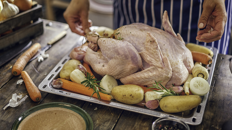 Chef prepares a raw turkey for cooking