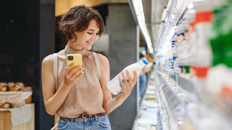 Person smiling at kefir jug