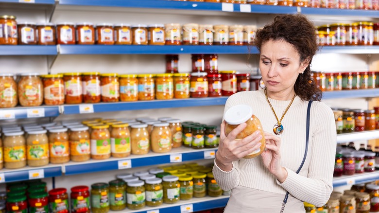 person looking at sauerkraut jar