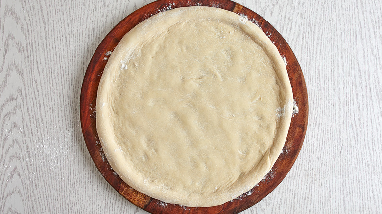 Rolled out raw pizza crust