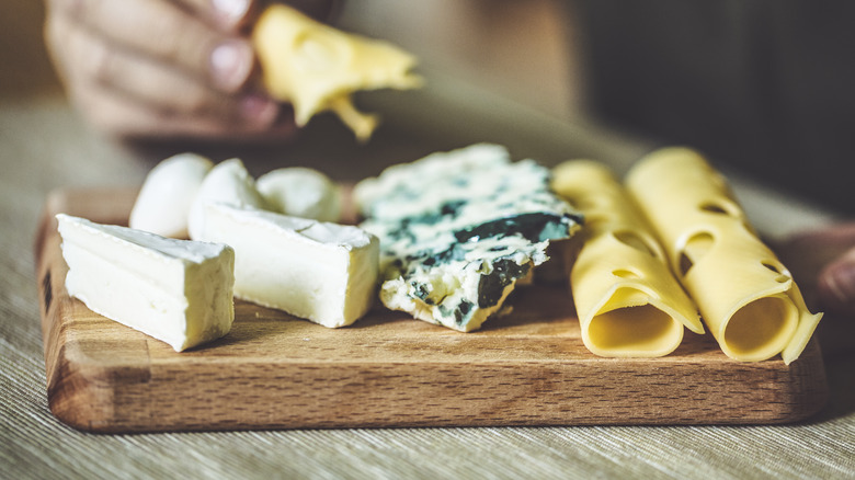 variety of cheese on a wooden board