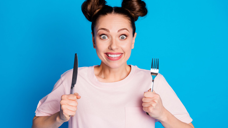 Woman holding fork and knife