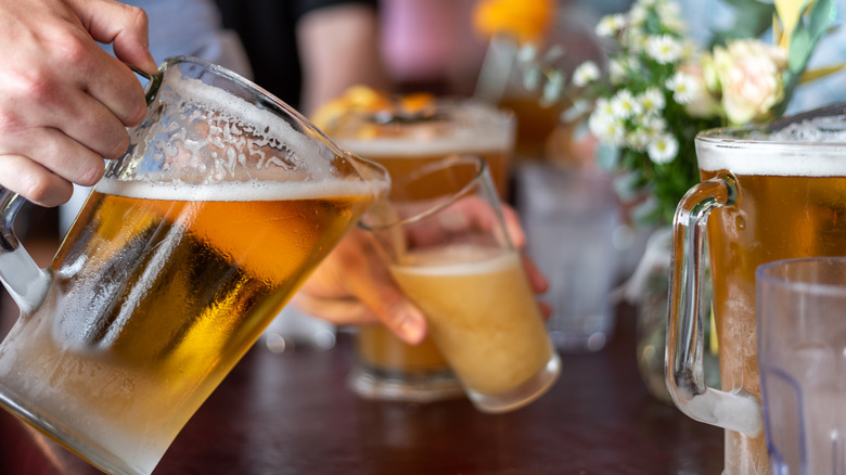 hand pouring beer pitcher