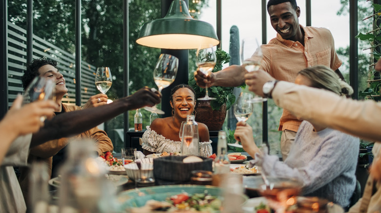 friends toasting around a dinner party table