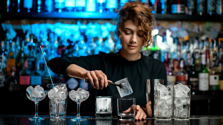 bartender with cocktail glasses with ice