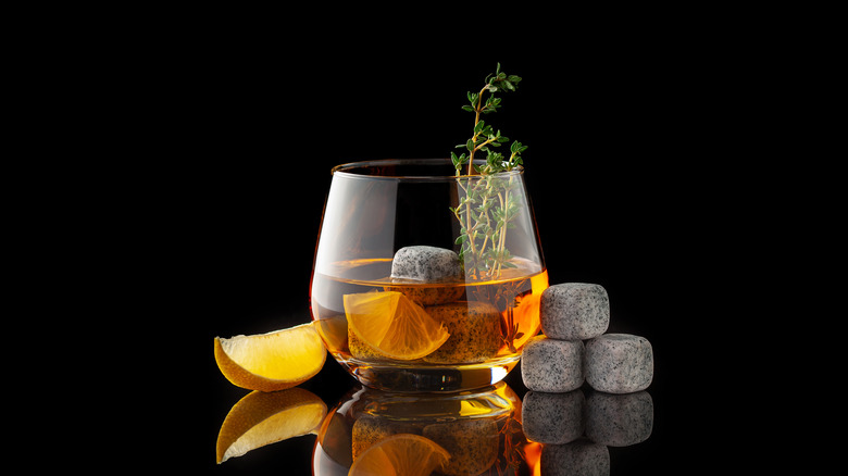 Cocktail with thyme, lemon, and whiskey stones