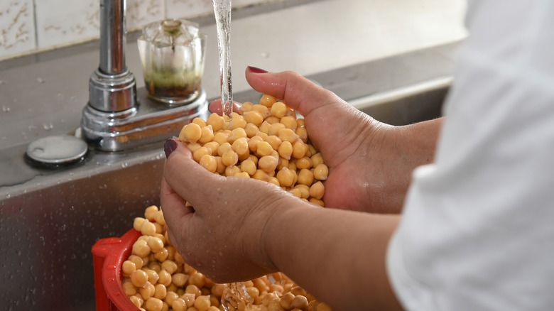 person washing chickpeas in sink