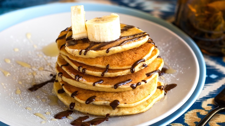 pancakes on plate with chocolate and banana