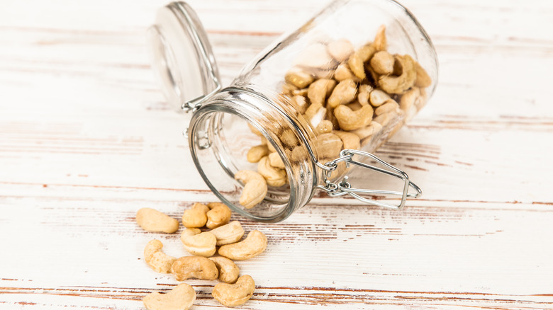 glass jar of cashews spilling