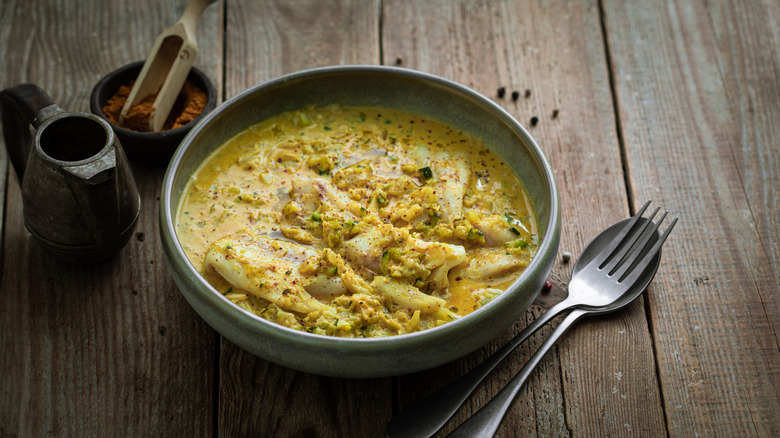 Cod curry in bowl with cutlery