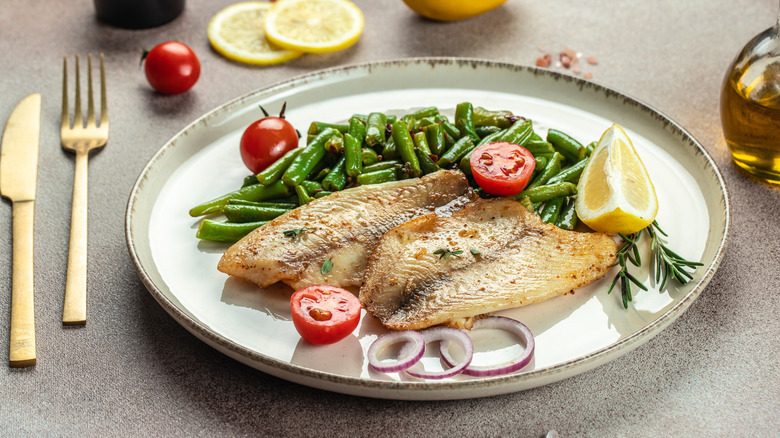 Baked tilapia fillets with green beans and garnishes