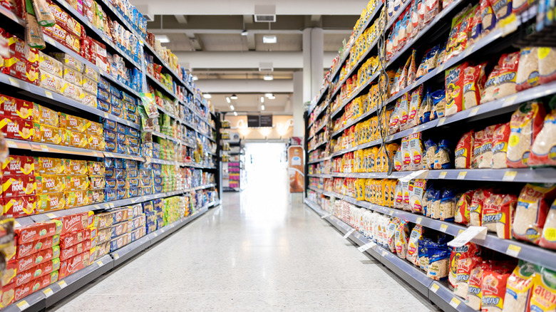 Supermarket aisle with shelves stacked with produce