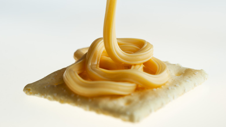 spray cheese on salty cracker