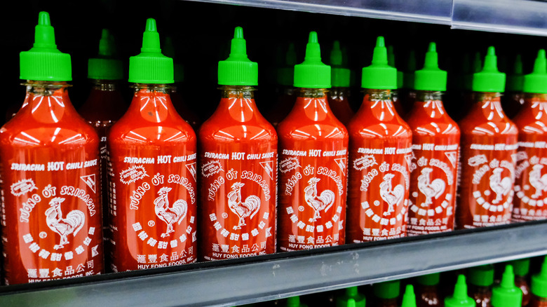 Sriracha bottles on a shelf 
