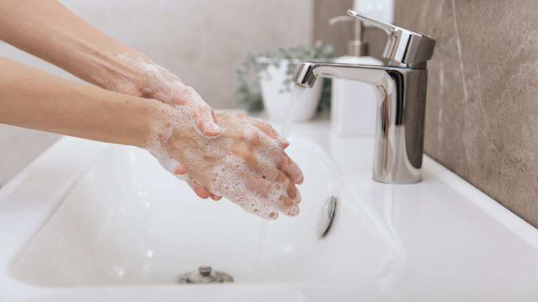 washing hands in sink with soap