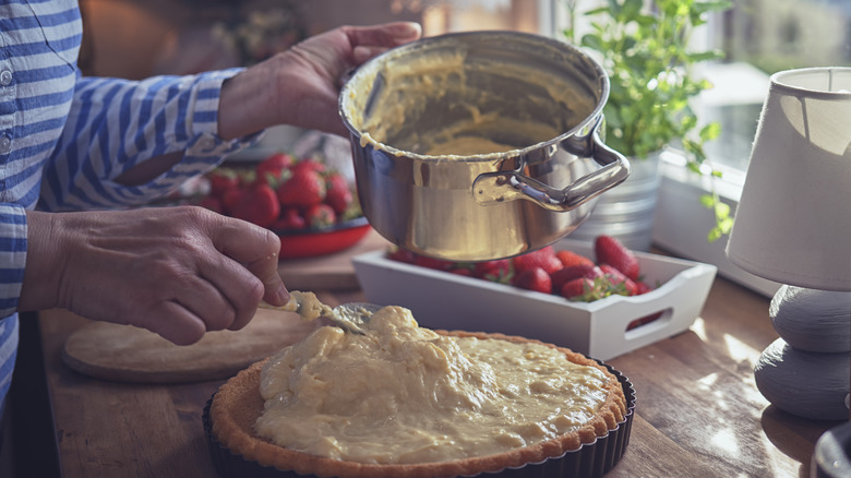 Woman making a strawberry cake with cream cheese