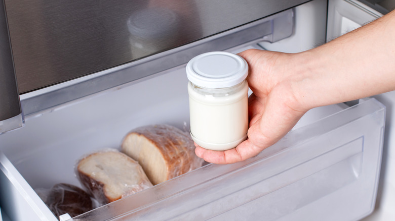 Man taking a jar of cream cheese out of the freezer