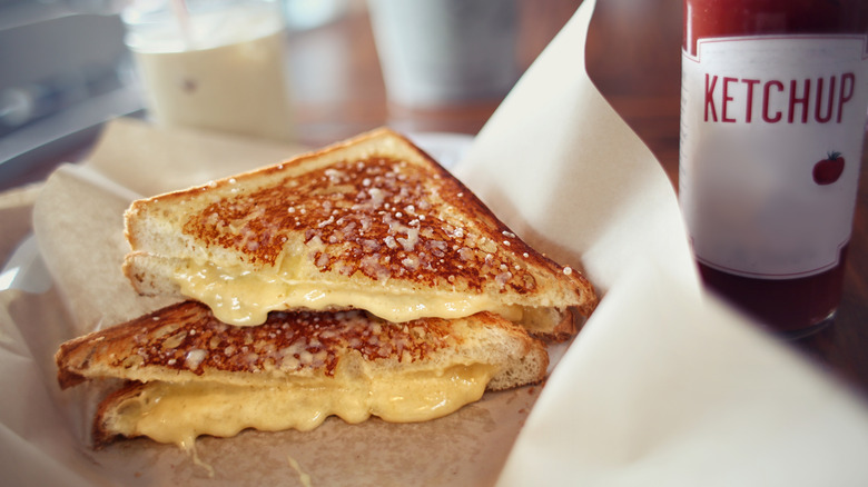 Halved grilled cheese sandwich on brown paper