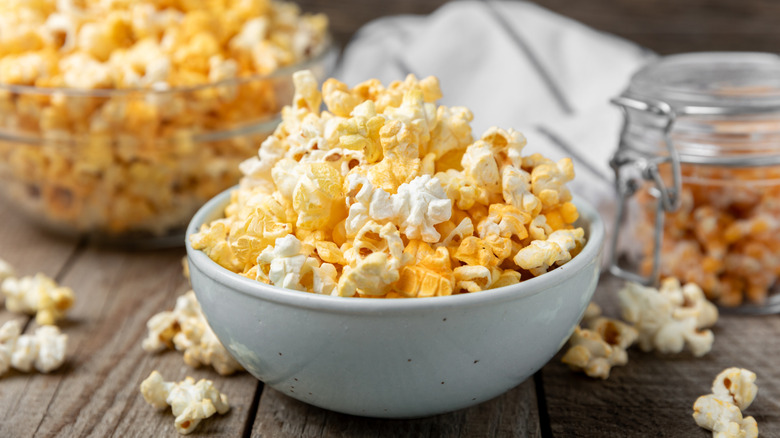 Yellow and white popcorn overspilling in a bowl.